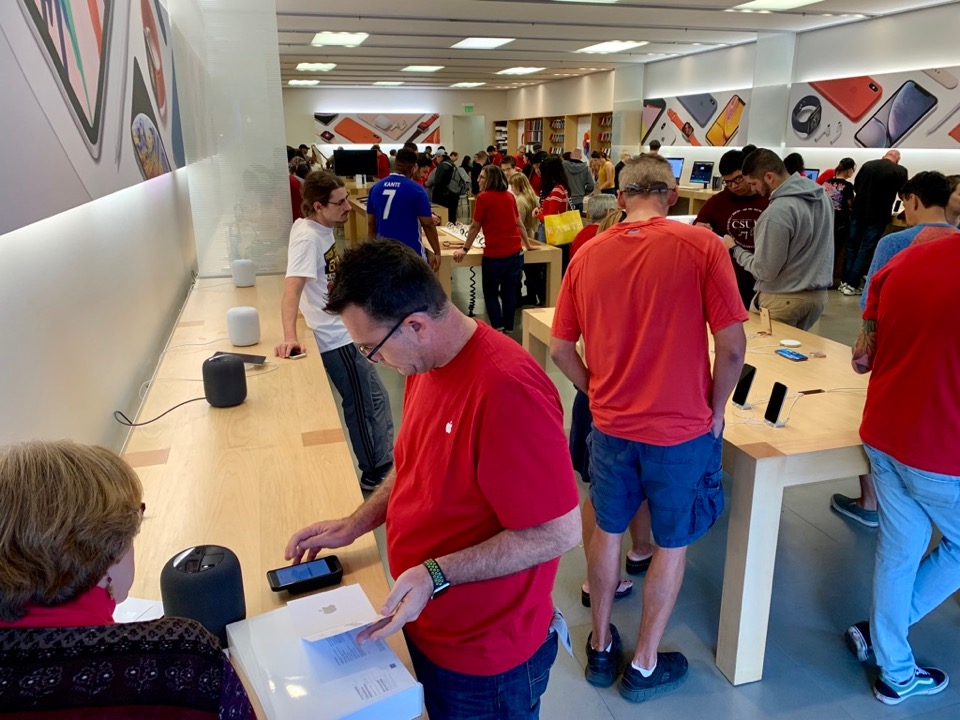 Customers and associates in a busy Apple retail store.